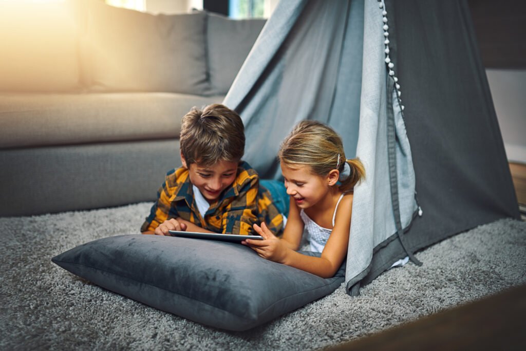 Tablet rest children tent home playing online educational game learning relax digital technology kid siblings watching video entertainment blanket fort fun home